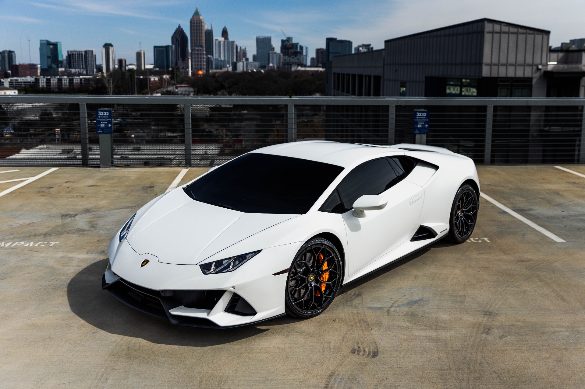 White Lamborghini Huracán with Atlanta skyline